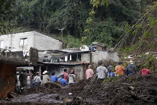 Habitantes de las zonas afectadas por las fuertes lluvias retiran lodo de sus viviendas este domingo, en Huauchinango, México. EFE/ Hilda Ríos