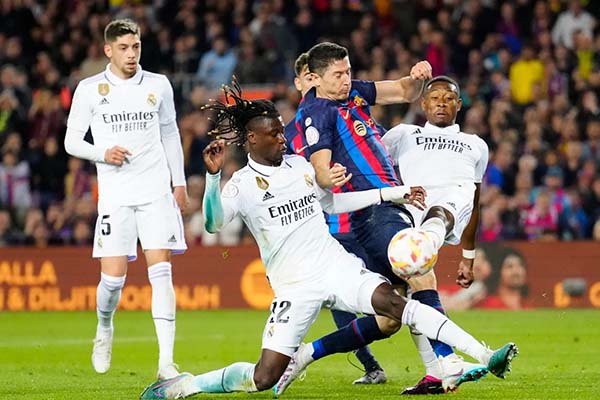 David Alaba y Eduardo Camavinga del Real Madrid, enfrentándose a Robert Lewandoski del Barcelona. Foto EFE 